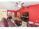 Bright living room features vaulted ceilings, red accent wall, tile floors and access to entry and other rooms at 27941 Austin Woods Dr, Dade City, FL 33525
