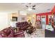 Spacious living room with red accent wall, tile floors, and ceiling fan provides a comfortable gathering space at 27941 Austin Woods Dr, Dade City, FL 33525
