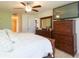 Main bedroom suite featuring a large television, dresser and access to main bathroom and walk-in closet at 27941 Austin Woods Dr, Dade City, FL 33525