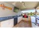 Outdoor kitchen under a covered patio, featuring modern appliances and a grill at 27941 Austin Woods Dr, Dade City, FL 33525