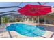 Pool featuring a red umbrella, patio, lights, and landscaping at 27941 Austin Woods Dr, Dade City, FL 33525