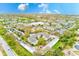 Expansive aerial view of the community, highlighting the landscape and nearby lake at 300 Promenade Dr # 106, Dunedin, FL 34698