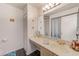 Bathroom featuring a wide vanity with ample counter space, a large mirror, and a neutral color scheme at 300 Promenade Dr # 106, Dunedin, FL 34698