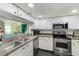 Functional kitchen with stainless steel appliances and a pass-through window at 300 Promenade Dr # 106, Dunedin, FL 34698