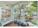 Relaxing screened porch with comfortable bench seating and views of the landscaped surroundings at 300 Promenade Dr # 106, Dunedin, FL 34698