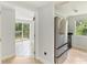 View into bright kitchen with stainless steel refrigerator and view of deck at 306 Chestnut St, Oldsmar, FL 34677