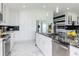 Open kitchen with white cabinets, black backsplash, stainless steel appliances, and bar stool seating at 31803 Sun Kettle Loop, Wesley Chapel, FL 33545