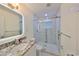 This bathroom features granite countertops, a modern mirror, and a glass shower door at 3218 N 16Th St, Tampa, FL 33605