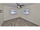 This bedroom features light gray vinyl plank flooring, two windows, and a ceiling fan at 3218 N 16Th St, Tampa, FL 33605