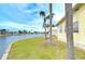 Waterfront property with lush landscaping, mature palm trees, and serene canal views at 35246 Tiffani Ct, Zephyrhills, FL 33541