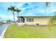 Spacious backyard with lush grass, mature palm trees, and waterfront canal access at 35246 Tiffani Ct, Zephyrhills, FL 33541