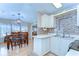 Functional kitchen with white cabinets, stainless steel appliances, and a dining area nearby at 35246 Tiffani Ct, Zephyrhills, FL 33541
