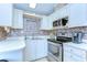 Compact kitchen with white cabinets, stainless steel appliances and accent tile backsplash at 35246 Tiffani Ct, Zephyrhills, FL 33541