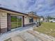 Inviting single-story home with glass sliding door, metal roof, and tidy front yard landscaping at 3751 Cullen St, New Port Richey, FL 34652