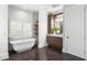 Elegant bathroom featuring a freestanding tub, dark floors, and a vanity with custom cabinets at 3801 Bayshore Blvd, Tampa, FL 33611