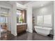 A bright bathroom with a freestanding tub, wood vanity, marble countertop, and a view of the ocean at 3801 Bayshore Blvd, Tampa, FL 33611