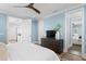 Light-filled bedroom with a ceiling fan, blue walls, and doorway leading to another room at 3801 Bayshore Blvd, Tampa, FL 33611