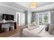 A relaxing bedroom with hardwood floors, tray ceiling, large window view, and seating provides ultimate comfort and style at 3801 Bayshore Blvd, Tampa, FL 33611