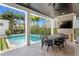Inviting outdoor dining area overlooking the pool, complete with a stone fireplace and TV at 3801 Bayshore Blvd, Tampa, FL 33611