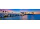 Long fishing pier extending over the water with tropical landscaping at sunset at 400 Beach Ne Dr # 1202, St Petersburg, FL 33701