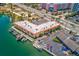 Aerial view of a building on the water with boat docks and parking at 4103 Gulf Blvd # 205, St Pete Beach, FL 33706