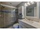 Well lit bathroom featuring a walk in shower and white marble vanity at 4103 Gulf Blvd # 205, St Pete Beach, FL 33706