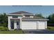 Modern home with a two-car garage, gray roof, and beautiful landscaping at 426 Sun Chaser Dr, Nokomis, FL 34275