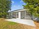 Exterior view of home's screened porch, surrounded by trees and a grassy backyard at 4320 Northampton Dr, New Port Richey, FL 34653