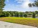 Picturesque backyard featuring a well-maintained lawn and a tranquil pond surrounded by lush greenery at 4320 Northampton Dr, New Port Richey, FL 34653