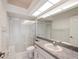 Well-lit bathroom featuring tile floors, a shower with sliding doors, and vanity with a large mirror at 4320 Northampton Dr, New Port Richey, FL 34653
