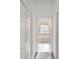 A bathroom view showing tile floors and a step-up tub with glass block window at 4320 Northampton Dr, New Port Richey, FL 34653