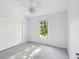 Bright bedroom featuring neutral carpet, ceiling fan, a window and a spacious closet at 4320 Northampton Dr, New Port Richey, FL 34653