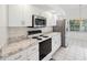 Bright kitchen featuring white cabinets, stainless steel appliances, and tile flooring at 4320 Northampton Dr, New Port Richey, FL 34653