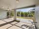 Spacious screened porch with tile flooring and views of lush trees and a serene pond at 4320 Northampton Dr, New Port Richey, FL 34653