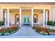 Inviting residents club entrance featuring white columns, rocking chairs, and vibrant flower beds at 5220 Brittany S Dr # 807, St Petersburg, FL 33715