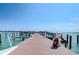 Long wooden dock extending into the water with boat and blue sky at 5220 Brittany S Dr # 807, St Petersburg, FL 33715