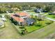 An aerial view shows the landscaped backyard and screened-in patio of the house with a Spanish tile roof at 6021 Flatwoods Manor Cir, Lithia, FL 33547