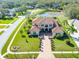 Expansive estate featuring a terracotta roof, manicured lawn, and a tranquil pond at 6021 Flatwoods Manor Cir, Lithia, FL 33547