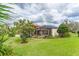 A shot of the backyard features a large screened-in patio and a well-manicured lawn surrounded by lush greenery at 6021 Flatwoods Manor Cir, Lithia, FL 33547