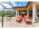 Covered patio with comfortable lounge chairs, outdoor grill, and lush greenery views at 6021 Flatwoods Manor Cir, Lithia, FL 33547