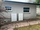 Back exterior of the home featuring Tesla power storage units with brick paver walkway at 7101 8Th N Ave, St Petersburg, FL 33710