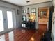 Living room with hardwood floors, guitar, french doors, and view into kitchen at 7101 8Th N Ave, St Petersburg, FL 33710
