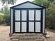 Storage shed with black trim, white paneling, and brick paver foundation at 7101 8Th N Ave, St Petersburg, FL 33710