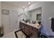 Bathroom featuring a double sink vanity, large mirror, and tile flooring for a clean and functional space at 10967 Carlton Fields Dr, Riverview, FL 33579