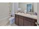 Bathroom featuring double sinks with dark wood cabinetry, a bathtub, and a toilet at 10967 Carlton Fields Dr, Riverview, FL 33579