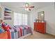 This bedroom boasts a ceiling fan, red-themed decor, and a red three-drawer dresser at 1420 High Knoll Dr, Brandon, FL 33511