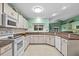 Bright kitchen features granite counters, white appliances, tile floor and fresh green paint at 1489 Ridge Shore Dr, Tarpon Springs, FL 34689