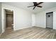 Neutral bedroom with wood-look flooring, ceiling fan, and ensuite bathroom at 1503 Council Dr, Sun City Center, FL 33573