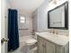 Updated bathroom with gray tile, marble vanity, and tub with shower at 1719 Belleair Forest Dr # B, Belleair, FL 33756