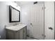 Bathroom with gray vanity, marble countertop and a framed mirror at 1719 Belleair Forest Dr # B, Belleair, FL 33756